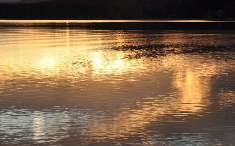 Sunset reflected on calm Okanagan Lake water